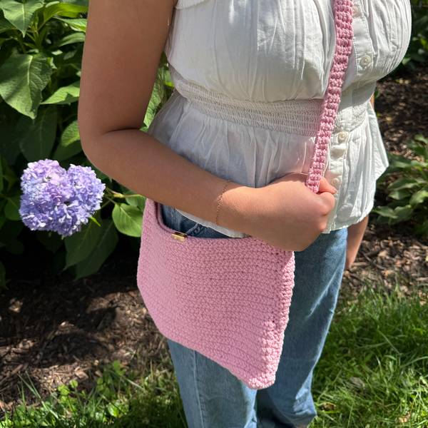 The purse worn crossbody over jeans and a white top